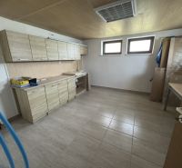 A kitchen in a family house with tiles and a countertop with a wooden decor.