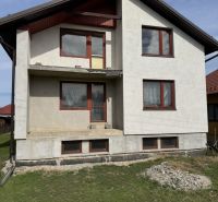 A family house in Plavnica with a simple facade and new windows, with a grassy plot.