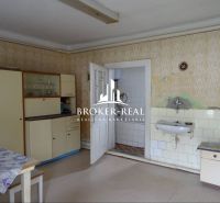 A kitchen in a family house with vintage furniture and a sink, floor with wooden decor.
