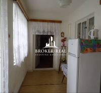 Interior of a family house with a white refrigerator and a floor decorated with a wooden pattern.
