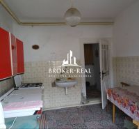 A kitchen in a family house with patterned tiles and red cabinets.