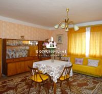 Living room in a family house with retro furniture and yellow curtains.