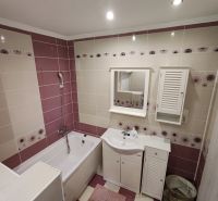 A bathroom with a shower bath and white furniture in a 3-room apartment.