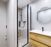 A bathroom with a shower and furniture with a wooden decor in a 3-room apartment.