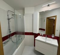 Bathroom with a bathtub, mirror, and sink in a 3-room apartment.