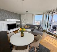 A living room in a three-room apartment with a round table and a floor with a wooden decor.