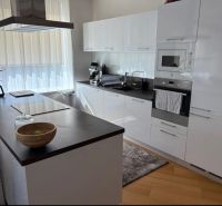 A kitchen in a 3-room apartment with white cabinets and a wooden decor floor.