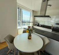 A kitchen in a 3-room apartment with a round table and a view, wooden decor flooring.