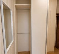 Built-in wardrobe with sliding doors and a wooden decor floor in a 2-room apartment.