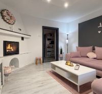 Living room in a family house with a fireplace, sofa, and decorative elements.