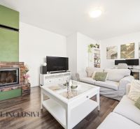 A bright living room in a 3-room apartment with a fireplace and a wooden decor floor.