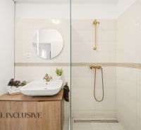 A bathroom in a 3-room apartment with colorful tiles and a mirror above the sink.