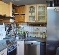 A kitchen in a 3-room apartment with built-in appliances and storage solutions.