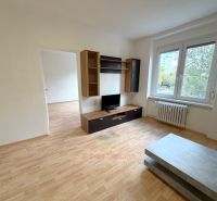 Living room with a TV stand, coffee table, and wooden decor flooring.