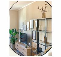 Living room in a 2-room apartment with a TV stand, plant, and decorations.