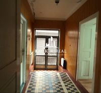 Wooden wall paneling and patterned flooring in the hallway of a family house.