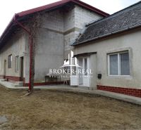 A family house in Sirník with an unplastered brick extension and a metal roof.