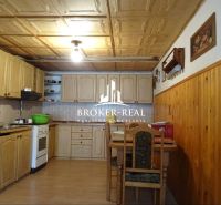 A kitchen in a family house with a wooden decor floor and a wooden ceiling.