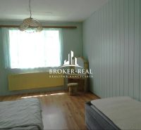 A room in a family house with a wooden decor floor and green walls.