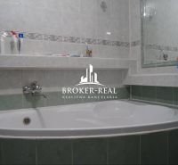 Bathroom with a bathtub and a mirror in a family house.