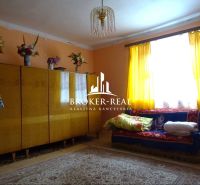 A living room in a family house with a colorful carpet and curtains.