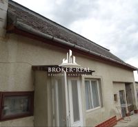 A family house in Sirník with traditional plaster and a sloped roof under an overcast sky.