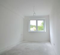 A spacious room with a large window in a 2-room apartment.