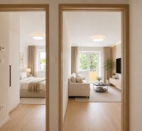 Interior of a 2-room apartment with a wooden decor floor and light furnishings.