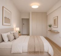 A bright bedroom in a two-room apartment with a bed and storage space.