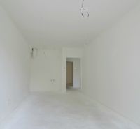 An empty room in a 2-room apartment with clean white walls and floor.