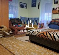 A room in a family house with a decorative throw and plush toys on the floor.