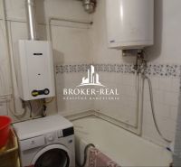 Bathroom in a family house with a gas boiler, washing machine, and bathtub.