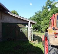 An old tractor next to a barn on the property of a family house in Abaújvár.