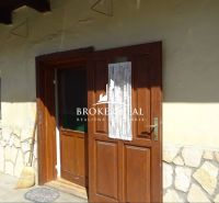 Wooden door with decorative glass, broom, and stone cladding in a family house in Abaujvár.