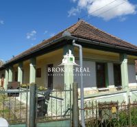 A family house in Abaujvár with a traditional roof and a green facade under a blue sky.