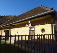 A family house in Telkibanya with a sloped roof, fenced, on the edge of a forest.