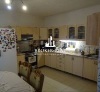 Kitchen interior with wooden decor in a family house, dominated by a light-colored kitchen unit.