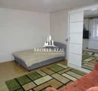 A room in a family house with a bed and sliding doors, a floor with a wood decor.