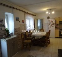 A kitchen in a family house with a dining table and decorative wall cladding.