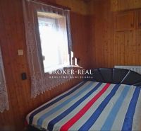 A bedroom with wooden wall decor and a double bed in a family house.