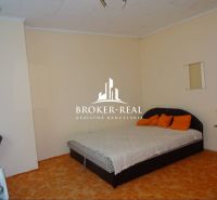 A bedroom in a family house with an orange carpet and a double bed.