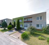 Family houses on 1st May Street in Brodské with landscaped greenery in front of the properties.
