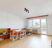 Living room in a family house with a dining table, armchairs, and a wooden decor floor.