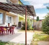 The terrace of a family house on 1st May Street in Brodské with plastic furniture and a pergola.