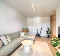 Living room with a large sofa and a wooden decor floor in a 3-room apartment.