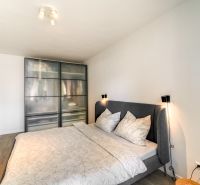 Bedroom in a 3-room apartment with a built-in wardrobe and bed, floor with wooden decor.