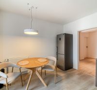 Dining area in a 3-room apartment with a wood-patterned floor and a dining table.