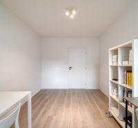 A study in a 3-room apartment with a desk and a shelving cabinet, floor with wood decor.