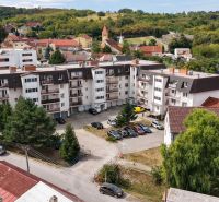 An apartment complex in the village of Banka on Podhorská Street surrounded by greenery and family houses.