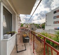 A balcony with flower pots and a chair in a 3-room apartment on Podhorská Street in Banka.